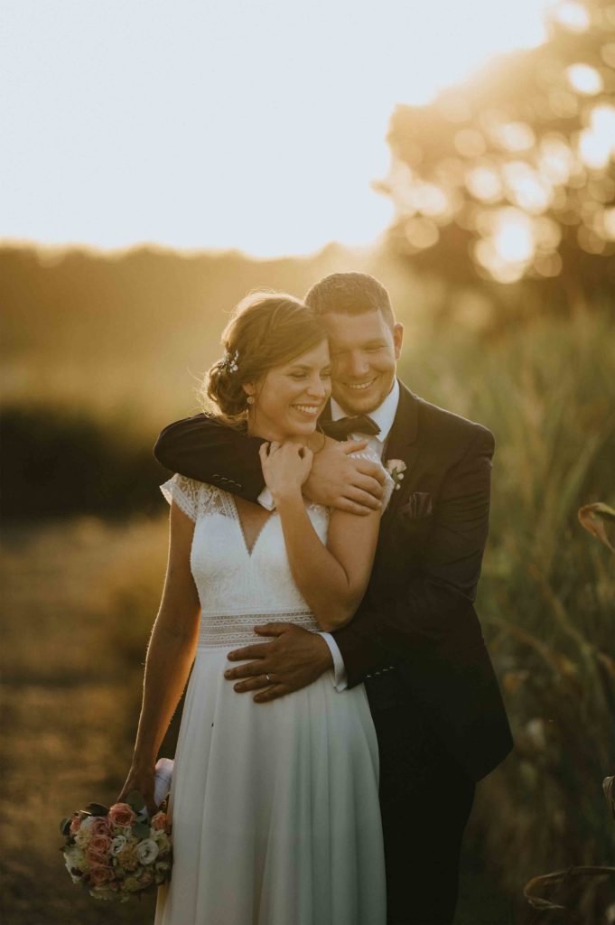 wundervolles inniges brautpaarfoto von einem hochzeitsfotografen bei sonnenuntergang zum besten licht in luxemburg