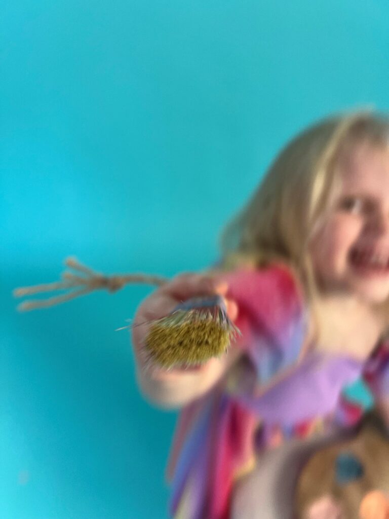 Color Sessions Trier: Türkiser Studiohintergrund mit Malpalette und Hocker für kreative Kinderfotos.